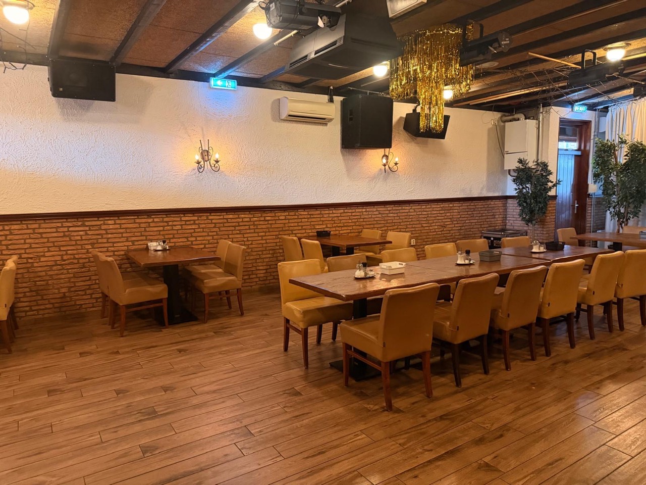 De zaal met houten tafels, klaar voor een bijeenkomst